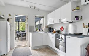 a kitchen with white cabinets and a dining room at Pet Friendly Home In Odder With Wifi in Odder