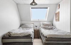 2 camas en una habitación pequeña con ventana en Nice Home In Korsr With Kitchen en Korsør