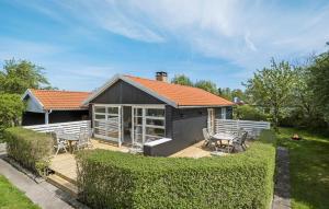 una pequeña casa con terraza y sillas en un patio en Cozy Home In Sydals With Kitchen, en Neder Lysabild