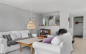 una sala de estar con 2 sofás blancos y una mesa. en Cozy Home In Sydals With Kitchen, en Neder Lysabild