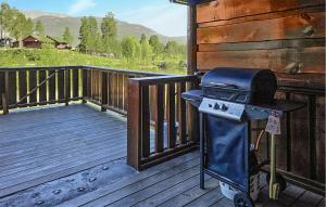 a grill sitting on a wooden deck on a porch at Nice Home In Vrådal With Kitchen in Vradal +9 photos