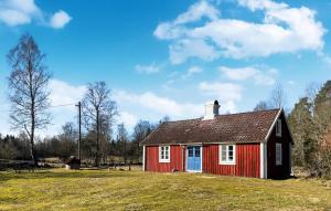 a red and white house in a field at 2 Bedroom Gorgeous Home In Hamneda in Annerstad +2 photos