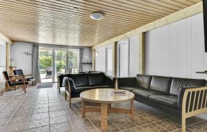 a living room with black leather furniture and a table at Four-Bedroom Holiday Home Humble With A Fireplace 01 in Humble