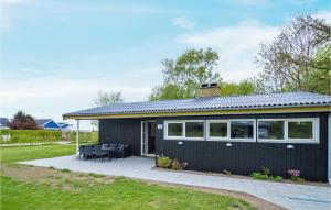 una pequeña casa negra con patio en Amazing Home In Kge With Kitchen en Strøby Egede