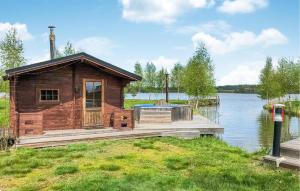 eine Holzhütte auf einem Dock auf einem See in der Unterkunft Cozy Home In Strngns With House Sea View in Aspö