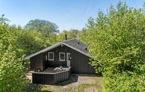 una cabaña negra en medio de los árboles en Amazing Home In Sydals With Wifi en Sønderby