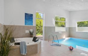 a large bathroom with a tub and a swimming pool at Amazing Home In Vejby With Kitchen in Vejby