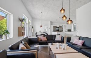 a living room with two couches and a table at Amazing Home In Vejby With Kitchen in Vejby