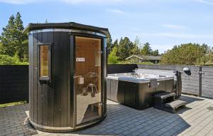 a wooden out house with a tub and a sink at Gorgeous Home In Blåvand With Sauna in Blåvand