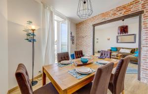 a dining room with a wooden table and chairs at Beautiful Apartment In Cancale in Cancale +8 photos