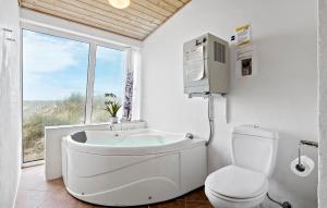 une salle de bain avec baignoire et toilettes dans l'établissement Cozy Home In Frøstrup With Sauna, à Frøstrup
