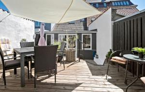 eine Terrasse mit einem Tisch, Stühlen und einem Sonnenschirm in der Unterkunft 1 Bedroom Awesome Home In Middelfart in Middelfart