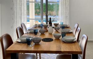 a wooden table with chairs and a large window at Villa Morosini in Rovinj