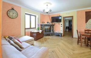 een woonkamer met twee witte banken en een klok bij Lovely Apartment In Roccamonfina With Kitchen in Roccamonfina