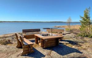 uma mesa de piquenique e banco na margem de um lago em Beautiful Home In Sffle With Kitchen em Säffle