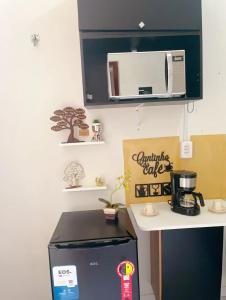 uma pequena cozinha com um micro-ondas e um frigorífico em •Incrível suíte com: acesso totalmente individual! em João Pessoa