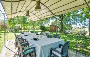 Una mesa larga con sillas debajo de una carpa. en Awesome Home In Ischia Di Castro, en Ischia di Castro