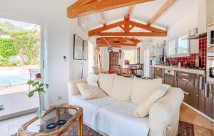 a living room with a white couch and a kitchen at 2 Bedroom Awesome Home In Les Issambres in La Garonnette-Plage