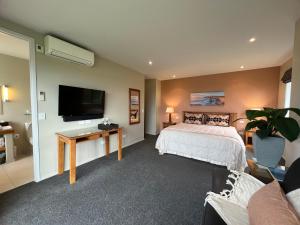 a bedroom with a bed and a flat screen tv at Manakau Lodge in Kaikoura