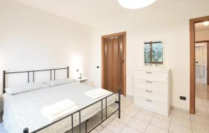 a white bedroom with a bed and a dresser at Pet Friendly Home In Varallo Pombia in Varallo Pombia