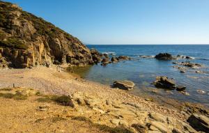 einen Strand mit Felsen und dem Meer an einem sonnigen Tag in der Unterkunft Casa Bella Vista in Torre Dei Corsari