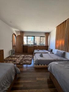 a bedroom with two beds and a large window at Nhà Sói Homestay Da Lat in Da Lat