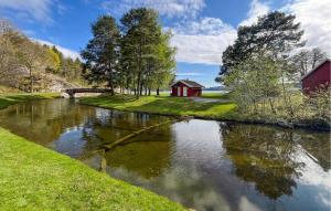 un río con un granero rojo y una casa roja en Beautiful Home In Porsgrunn With House A Panoramic View, en Porsgrunn