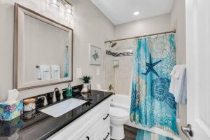 ein Badezimmer mit Waschbecken und Duschvorhang in der Unterkunft Hot Tub, Gas Grill, Tiki Bar w/TV, Dog Friendly in Bolivar Peninsula + 45 Fotos