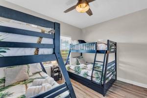 1 Schlafzimmer mit 2 Etagenbetten und einem Deckenventilator in der Unterkunft Hot Tub, Gas Grill, Tiki Bar w/TV, Dog Friendly in Bolivar Peninsula