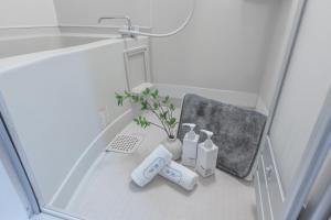 een badkamer met een wastafel en een vaas met een plant bij 桜の川6 Asakusa 704 Skytree bus 1 min,free wifi,cook,24 hours convenience in Tokyo