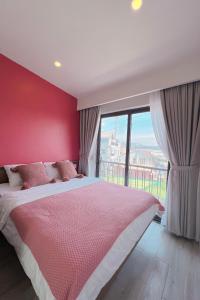 a bedroom with a large bed with a red wall at El Pino House in Khu Chi Lăng