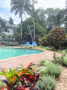 2 sillas azules sentadas junto a una piscina en Muthaiga House, en Margate