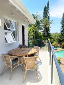 a wooden table and chairs on the balcony of a house at Muthaiga House in Margate +6 photos