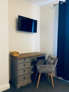 escritorio con silla y TV en la pared en Blue Bell, en Rothwell