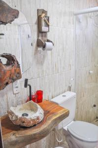 a bathroom with a toilet and a wooden counter at Cantinho do Tigela in Bananeiras
