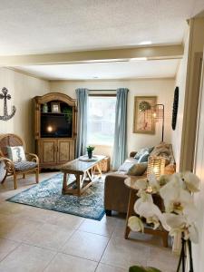 een woonkamer met een bank en een tafel bij Beach Happy 4bedrooms-3bath steps to beach in Virginia Beach