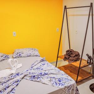 a bed in a room with a yellow wall at Cantinho do Tigela in Bananeiras