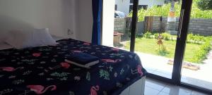 Una cama con una manta azul con flamencos rosas. en Giri Homestay, en Amed