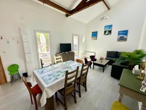 un soggiorno con tavolo, sedie e divano di Maison lumineuse au cœur d'Arcachon, plage à 200m, terrasse privée ! - FR-1-420-148 ad Arcachon Altre 15 foto