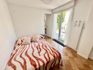 una camera da letto con un letto e una grande finestra di Maison lumineuse au cœur d'Arcachon, plage à 200m, terrasse privée ! - FR-1-420-148 ad Arcachon