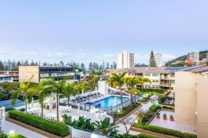 un resort con piscina, palme e edifici di Burleigh Beachside Retreat a Gold Coast