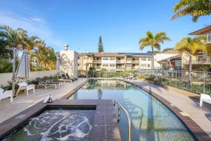 una piscina con un complesso turistico sullo sfondo di Burleigh Beachside Retreat a Gold Coast