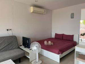 Schlafzimmer mit einem Bett, einem Ventilator und einem Sofa in der Unterkunft Bann Kanchana in Bangrak Beach