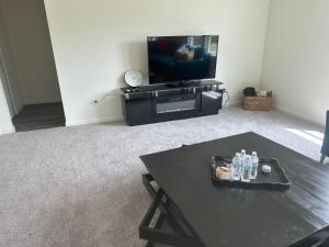 a living room with a tv and a coffee table at Cozy modern retreat 20 minutes from Downtown dallas Spacious fresh in Glenn Heights