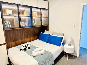 um quarto com uma cama com almofadas azuis em Modern Comfy 3 Bedrooms House in Chartwell em Hamilton