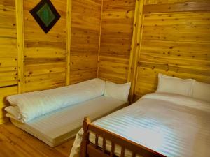 um quarto com duas camas num chalé de madeira em Lysa House em Lao Cai