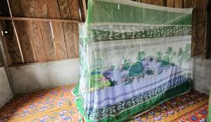 ein Bett, das mit einem Kunststoffblech in einem Zimmer bedeckt ist in der Unterkunft KIA HOMESTAY in Banggai