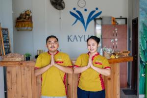 a man and a woman doing yoga in front of a counter at Kayuma House Canggu in Canggu
