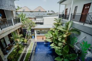 an overhead view of a swimming pool in a building with palm trees at Kayuma House Canggu in Canggu