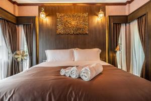 1 dormitorio con 1 cama con 2 pares de zapatillas en Khum Damnoen Resort en Ratchaburi